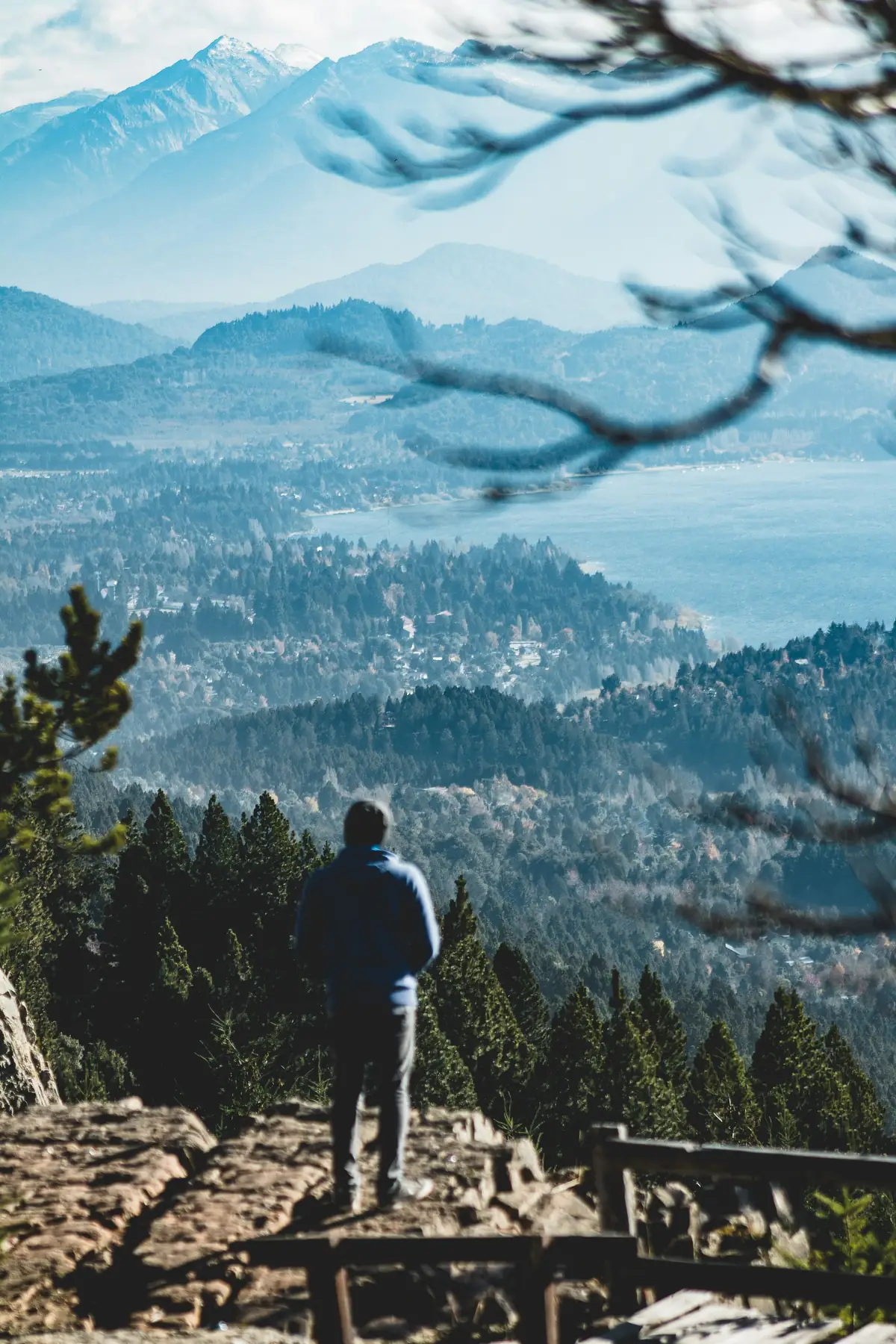 A man standing on a ridge, looking out over a mountain valley